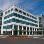 Modern office building with a glass facade and landscaped surroundings