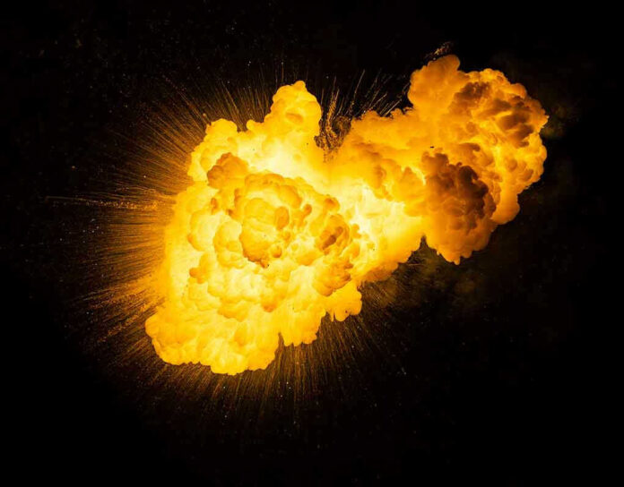 1791558833 Bright, fiery explosion against a dark background.