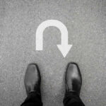 Trump’s Shocking Diplomatic U-Turn on Maduro Feet in black shoes facing U-turn road marking.