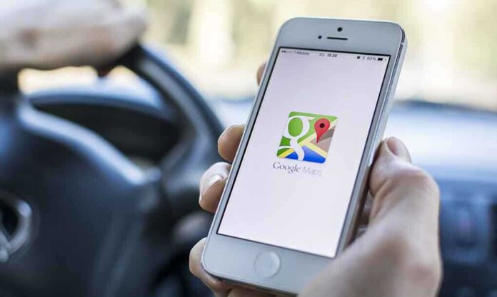 shutterstock_176093684.jpg A person holding a smartphone displaying the Google Maps app while driving