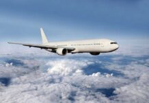 Airbus A320 Crisis — HALF the Fleet Grounded? A white airplane flying above fluffy clouds in a blue sky