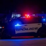 Police Car RAMS Armed Naked Gunman Houston police vehicle with emergency lights activated at night