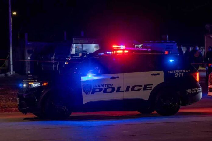 shutterstock_2414107305.jpg Houston police vehicle with emergency lights activated at night
