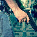 Shoot ICE On Sight? Shocking NJ Arrests Unfold Person holding a gun in a crowded street.