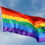 Progressive Organizers CAUGHT in Stunning Contradiction A rainbow flag waving against a blue sky