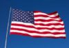 Waving American flag against a clear blue sky
