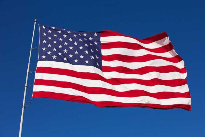 shutterstock_160994414.jpg Waving American flag against a clear blue sky