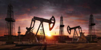 Oil rigs operating at sunset in a desert landscape.