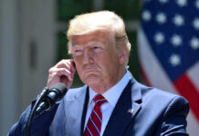 Shockwaves as Omar’s Tweet Ignites Execution Debate Man in a suit adjusting an earpiece.