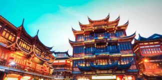 Illuminated traditional Chinese buildings in a bustling urban area at night