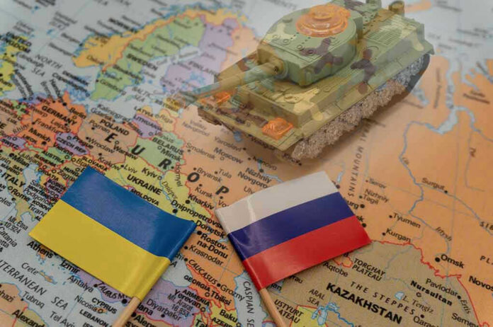 2114384846 Toy tank on map with Ukraine and Russia flags.