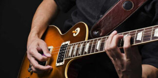 Hands playing an electric guitar.