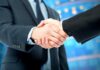 Two business professionals shaking hands in a corporate setting