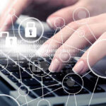 Hands typing with cybersecurity icons overlay.