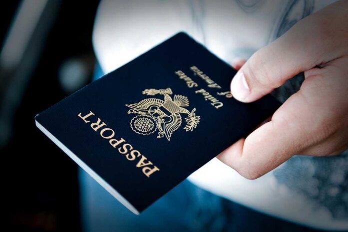 Image,Of,A,Persons,Hand,Holding,A,Passport A person holding a United States passport with a dark background
