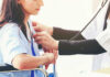 Doctor examining patient with stethoscope in hospital