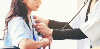 Doctor examining patient with stethoscope in hospital
