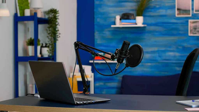1939096570 Laptop and a microphone on a desk.