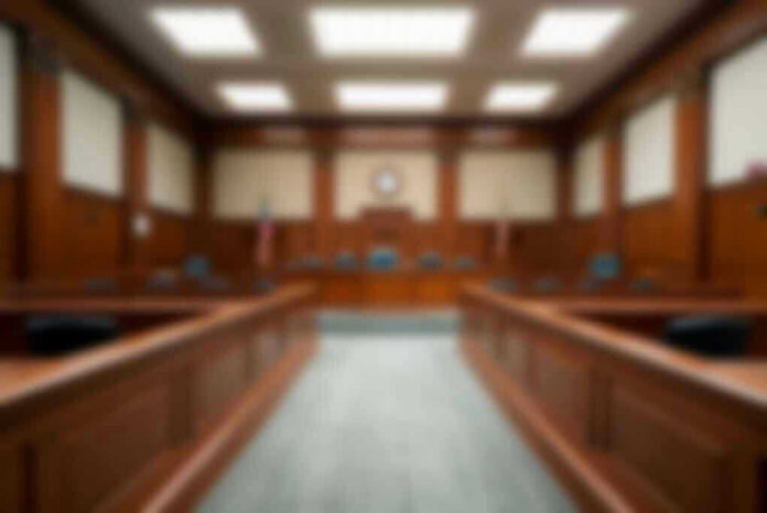 2324977165-2 Empty courthouse courtroom with wooden benches and chairs.