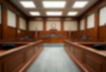 Mayor’s Brother Jumps In — LA On Trial Empty courthouse courtroom with wooden benches and chairs.
