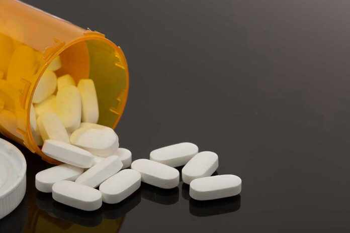 757565809 Spilled prescription bottle with white pills.