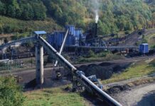 Industrial coal processing facility with conveyor belts and smoke stack