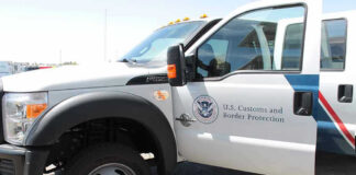 U.S. Customs and Border Protection truck with open door.