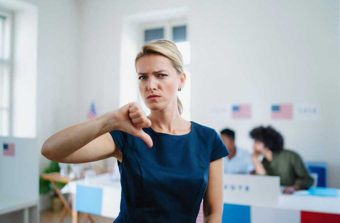 1823718170 Woman with thumbs down in voting location.