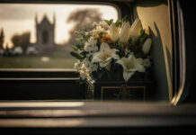 Sudden Senator Death Sparks Vile Pile-On White flowers in a car with blurred background.