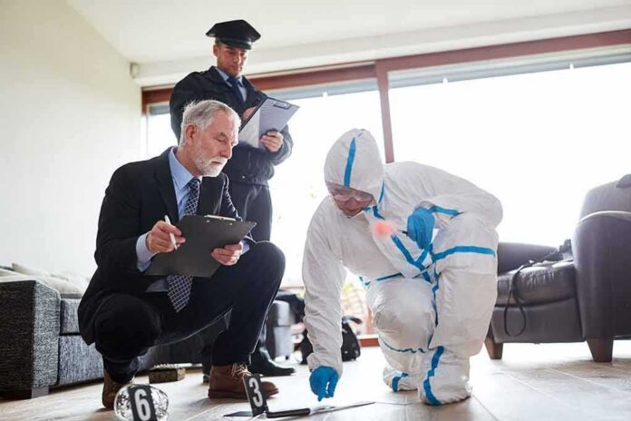 shutterstock_1455188570 forensic investigator in protective suit collects evidence while colleagues take notes