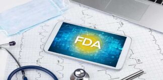 Tablet with FDA on screen amid medical tools and ECG charts