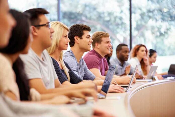 shutterstock_218235067 A diverse group of students attentively listening in a classroom setting