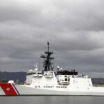 Containment Fails? Diesel Drenches Harbor A U.S. Coast Guard ship docked under cloudy skies