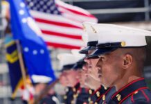 Military Recruiting Rebound Stuns Pentagon U.S. Marines in uniform standing in formation with flags in the background