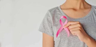 Person holding a pink ribbon on a gray shirt