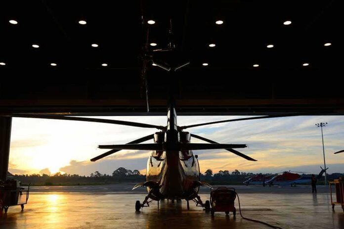 shutterstock_110965106-1 Helicopter in a hangar at sunset