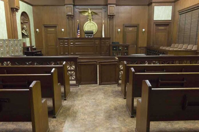 shutterstock_121502665 Interior view of an empty courtroom with wooden benches and a judges bench
