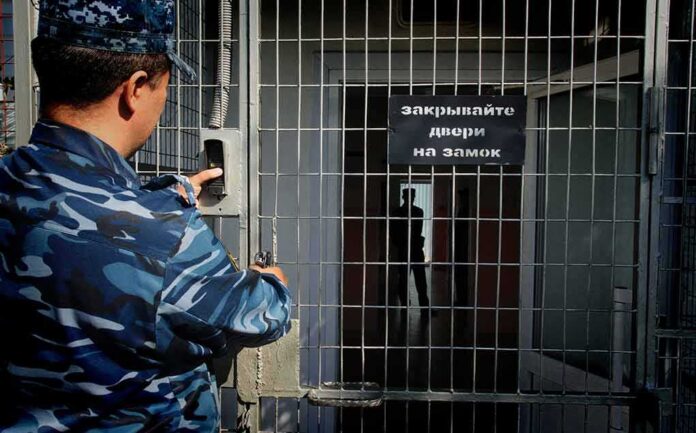 shutterstock_1497596957 Security officer locking a metal gate with keypad