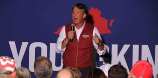 Speaker addressing a crowd on stage with a microphone