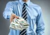 Crowdfund Frenzy After Clancy Juror Standoff Person in business attire offering bundles of US dollar bills