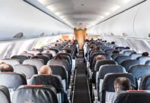 Airplane cabin with passengers seated in rows