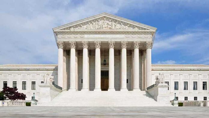 shutterstock_132568517-1 Front view of the Supreme Court building with large columns and steps under a blue sky