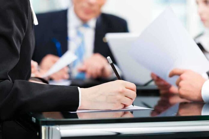 shutterstock_137911247 Close-up of a hand writing notes during a business meeting