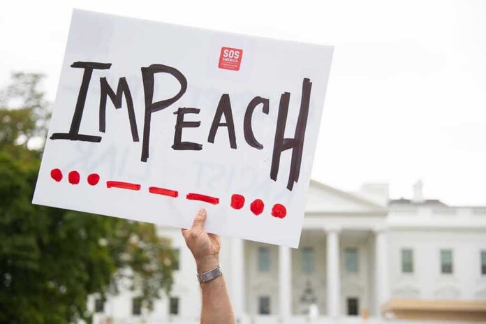 Protester holds an impeach sign in front of a white government building