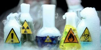 laboratory flasks with hazard symbols and colorful liquids