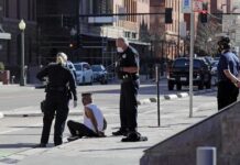 Off-Duty Mom Cop Foils Sidewalk Snatch Police officers detain a seated man on a city sidewalk