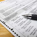 Voting Starts NOW: North Carolina Jumps First Ballot paper with pen on wooden surface