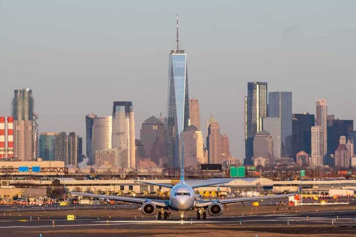 shutterstock_2196696959 Airplane taxiing on runway with city skyline in background