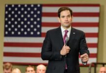man in suit speaking into a microphone