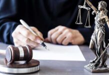 Stopped a Shooter – Then Got Probation Judge writing at desk with gavel and Lady Justice statue